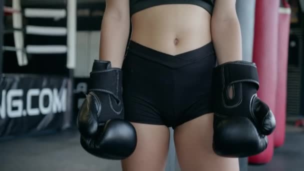 Beautiful athletic woman training boxing in the gym. Lifts the boxing gloves up. Ready for fight. — Stok video
