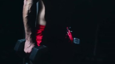 Young sportsman lifting heavy kettlebells. Picking up kettlebells from the floor.