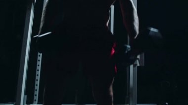 Young sportsman putting kettlebells on the floor after workout.