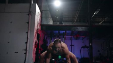 Bir spor salonu, sağlıklı bir yaşam tarzı ve fitness kavramı düşük açılı görünümünde büyük kauçuk lastik kaldırma dışarı çalışma crossfit egzersiz yapan uygun kaslı erkek