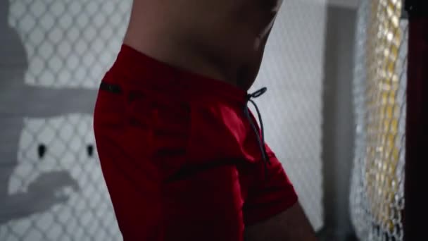 Lutador de MMA muscular está entrando na gaiola de octógono e fechando-a. — Vídeo de Stock