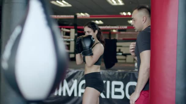 Vacker kvinna boxningssäck med sport tränare tillsammans. Boxer Boxningssäck flicka med personlig tränare. — Stockvideo