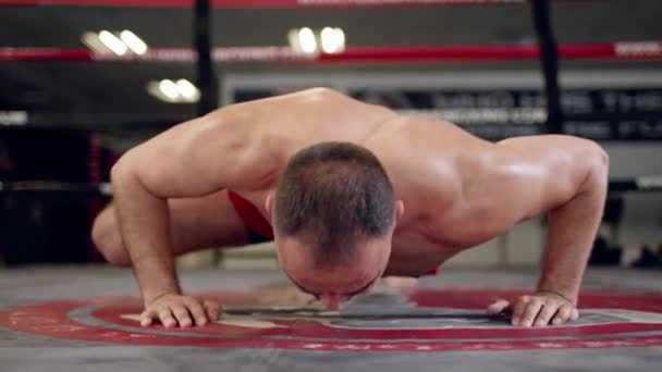 Мускулистый мужчина без рубашки, покрытый потом отжимания в спортзале. — стоковое видео