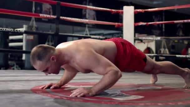 Muscular Shirtless Man Covered in Sweat Does Push-ups in a Gym. — Stock Video