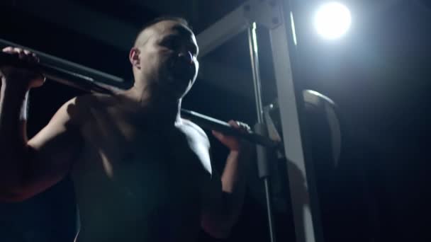 Ung idrottsman lyfter tung skivstång. Hård träning av professionell idrottsman, mörk bakgrund. — Stockvideo