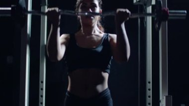 Athletic Beautiful Woman Does Overhead Lift with a Barbell in the Gym.