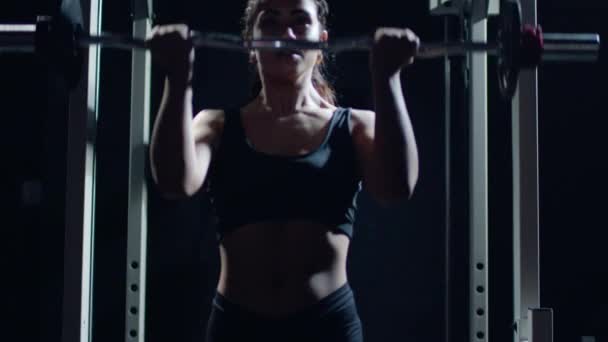 운동 선수인 아름다운 여인 이 머리를 들고 체육관에 있는 바벨 을 들고 들어선다. — 비디오