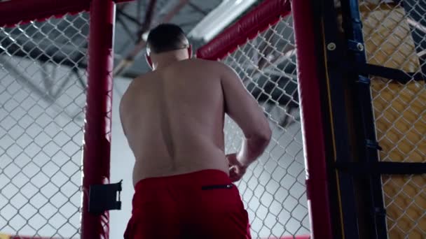 Svalnatý stíhač MMA vstupuje do osmiúhelníkové klece a zavírá ji. — Stock video