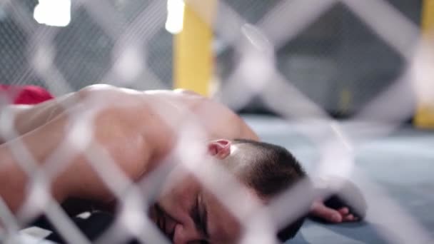 Combattente MMA sta cadendo sul pavimento dopo essere stato colpito e si alza rapidamente per continuare la lotta. — Video Stock