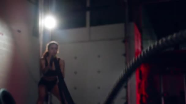 Entrenamiento activo dedicado a la mujer atleta motivada en el gimnasio con cuerdas de batalla. — Vídeos de Stock