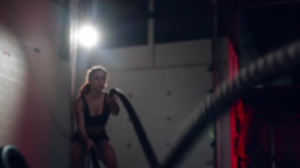 Active dedicated motivated female athlete training in gym with battle ropes. — Stock Video