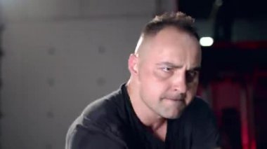 Assertive man doing exercises with battle rope, ruthlessly effective workout.