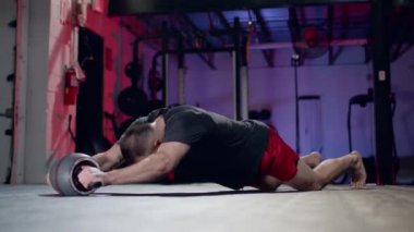 Sağlıklı bir adam spor envanterini kullanarak endüstriyel spor salonunda şınav çekmek için çok çaba sarf eder..