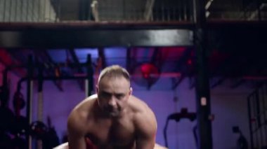 Bir spor salonu, sağlıklı bir yaşam tarzı ve fitness kavramı düşük açılı görünümünde büyük kauçuk lastik kaldırma dışarı çalışma crossfit egzersiz yapan uygun kaslı erkek.