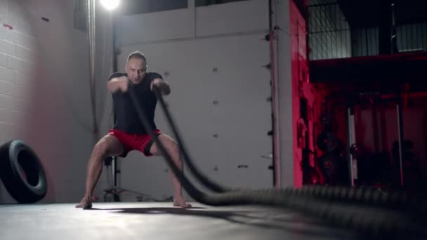 Homem assertivo fazendo exercícios com corda de batalha, exercício implacavelmente eficaz. — Vídeo de Stock