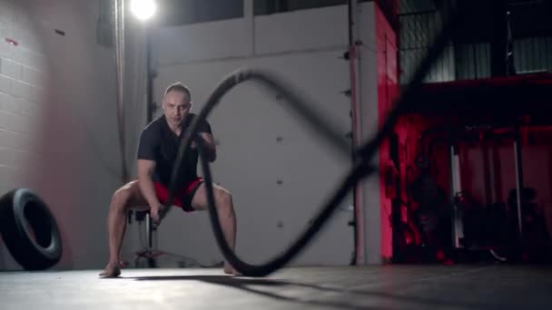 Помітний чоловік робить вправи з бойовою мотузкою, безжально ефективне тренування . — стокове відео