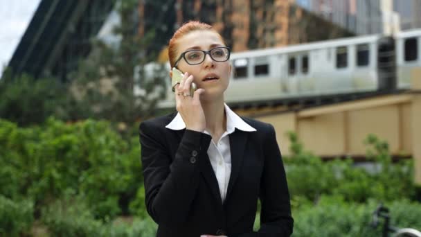 Giovane donna d'affari con i capelli rossi zenzero parlando sul telefono cellulare in città. — Video Stock