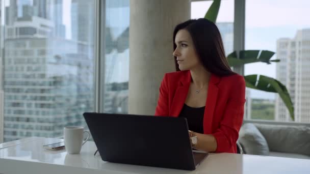 Triste donna d'affari è seduto in ufficio moderno dalla finestra panoramica con vista sulla città e guardando alla finestra. — Video Stock