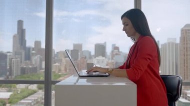 Smiling young business woman receptionist wear wireless headphone video conference working on laptop computer.