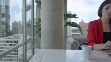 Smiling young business woman receptionist wear wireless headphone video conference working on laptop computer.
