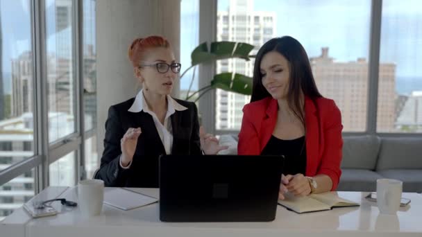 Две деловые женщины работают вместе в офисе с отчетами и ноутбуком. Перерыв, разговоры друг с другом. — стоковое видео