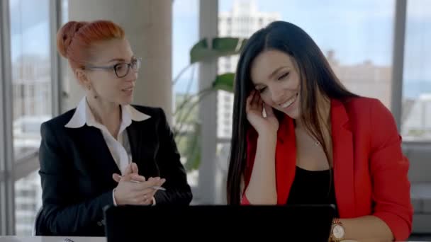 Dos mujeres de negocios trabajando juntas en la oficina con informes y laptop. Tomando un descanso, hablando entre sí. — Vídeos de Stock