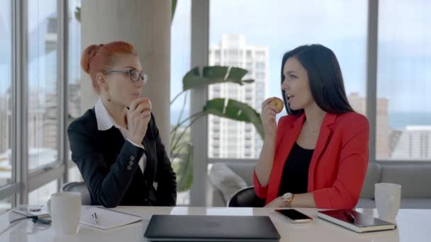 Dos mujeres de negocios trabajando juntas en la oficina con informes y tomando un descanso para el almuerzo. — Vídeo de stock