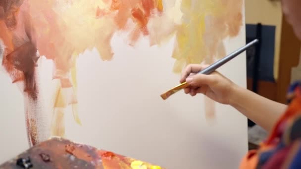 Mujer artista está dibujando sobre lienzo con pintura al óleo y empapando el pincel en la pintura. — Vídeos de Stock