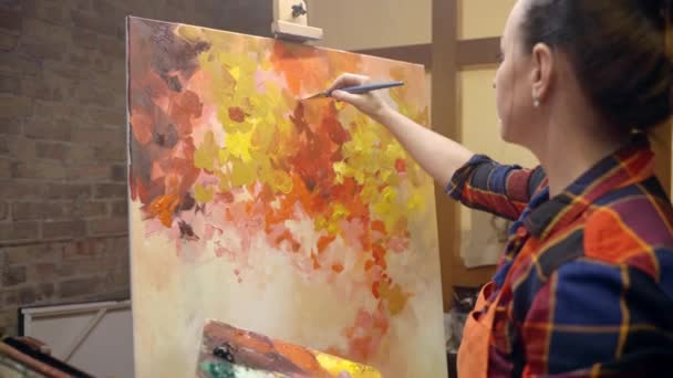 Mujer artista está dibujando sobre lienzo con pintura al óleo. — Vídeos de Stock