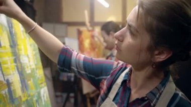 Kadın sanatçılar tuvale ve yağlı boyaya resim çiziyor. Tuval üzerine çizim.