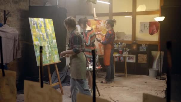 Les femmes artistes dessinent sur des toiles avec un pinceau. Atelier de peinture. — Video