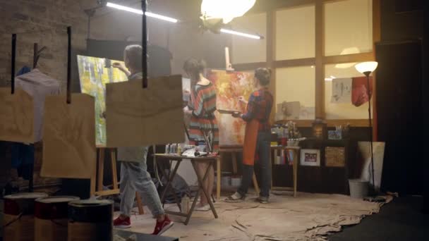 Mulheres artistas estão desenhando em telas com um pincel. Oficina de pintura. — Vídeo de Stock