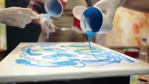 Des femmes artistes versent de la peinture acrylique sur la toile. Collaboration artistique en atelier. Vidéo De Stock Libre De Droits