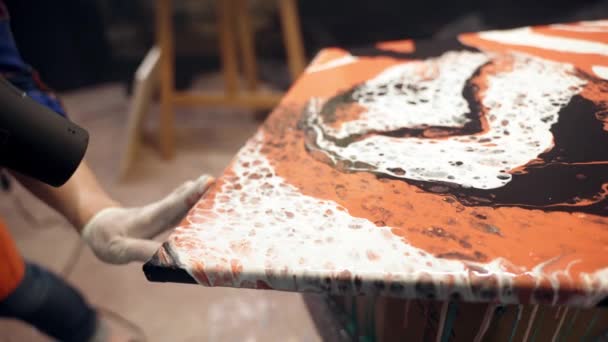 Les artistes femmes assèchent la peinture acrylique sur la toile avec un ventilateur. Collaboration artistique en atelier. Clip Vidéo