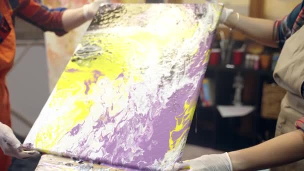 Οι καλλιτέχνες του Wome φτιάχνουν ακρυλικούς πίνακες. Η ακρυλική μπογιά απλώνεται πάνω από τον καμβά. Καλλιτεχνική συνεργασία στο εργαστήριο. — Αρχείο Βίντεο