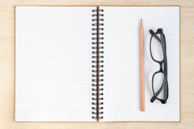 Ahşap arka plan - masa üstü görünüm üstünde açık spiral defter