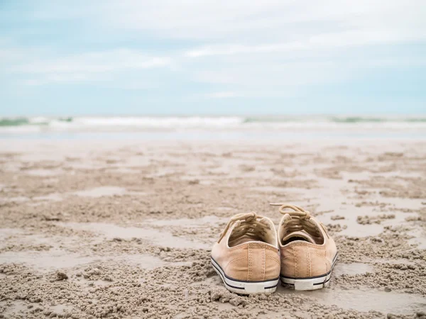 Zapatos de lona en la playa — Foto de Stock