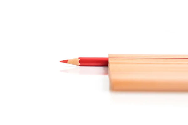 Isolated red colored pencil stand out of other brown pencils — Stock Photo, Image