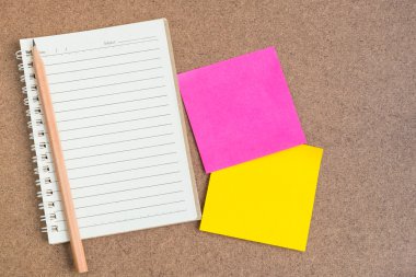 Açık defter ile kahverengi zemin üzerine yapışkan notlar