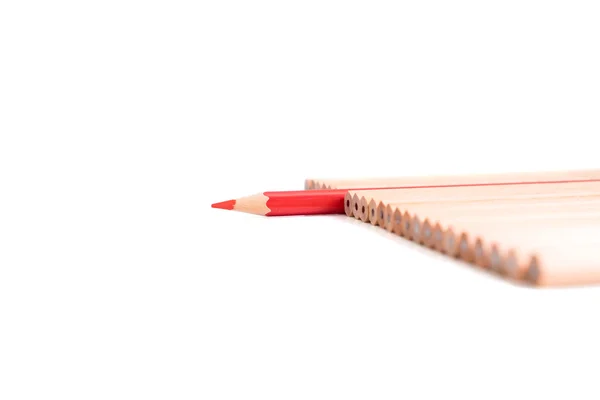 Isolated red colored pencil stand out of other brown pencils — Stock Photo, Image