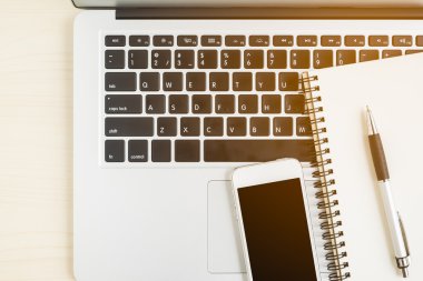 Dizüstü bilgisayar, cep telefonu, not defteri ve kalem yukarıda Resepsiyon