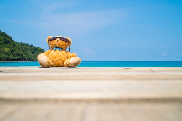 Καφέ αρκούδα κούκλα κάθονται στο ξύλινο πάτωμα στη θάλασσα — Φωτογραφία Αρχείου