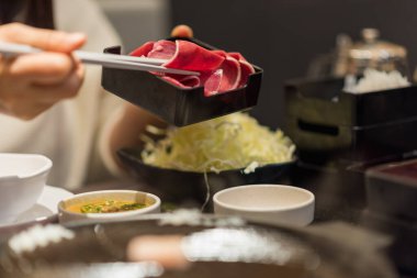 Tayland 'daki BBQ restoranında demir tavada ince dilimlenmiş domuz eti.