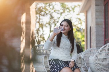 Genç Asyalı kadın içme suyu, bulanık arka plan, kopyalama alanı