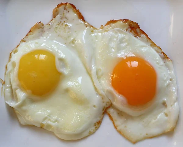 Dvě Smažená Vejce Vaječnými Žloutky Různých Barev — Stock fotografie
