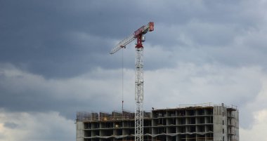 Bulutlu bir günde bir evin inşasında bir vinç.