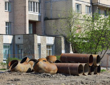 Geniş çaplı metal borular, Bolşevikov Bulvarı, Saint Petersburg, Rusya, Mayıs 2021 'de bir yerleşim yerinin duvarına yığılmış.