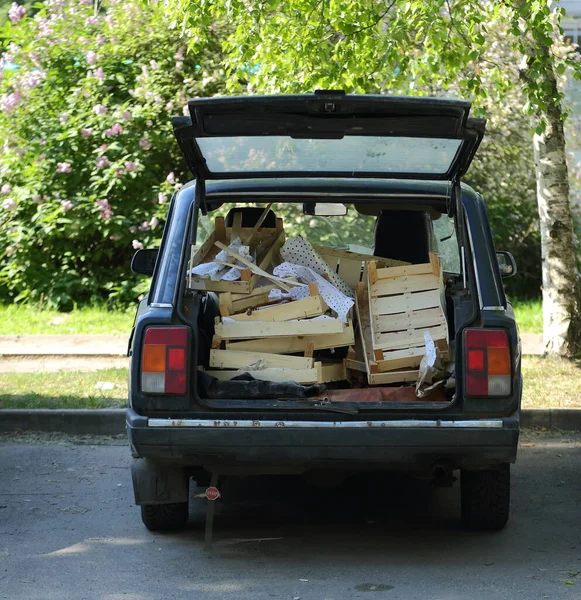 車のトランクは壊れた木製の箱で満たされている — ストック写真