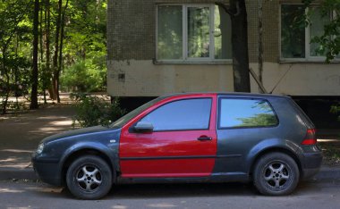 Ulitsa Podvoyskogo, St. Petersburg, Rusya, Temmuz 2021 'de bir apartmanın avlusunda kırmızı kapılı eski bir siyah araba.