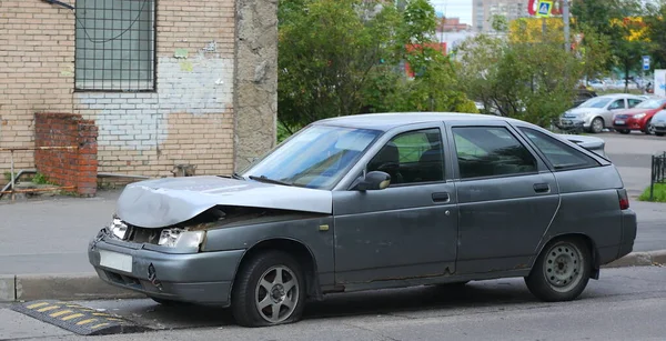 Paslı, koyu gri bir araba kaldırımda duruyor. Podvoysky Caddesi, St. Petersburg, Rusya, Ağustos 2021.